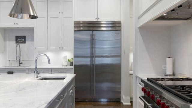 A sleek modern kitchen featuring stainless steel appliances and marble countertops.